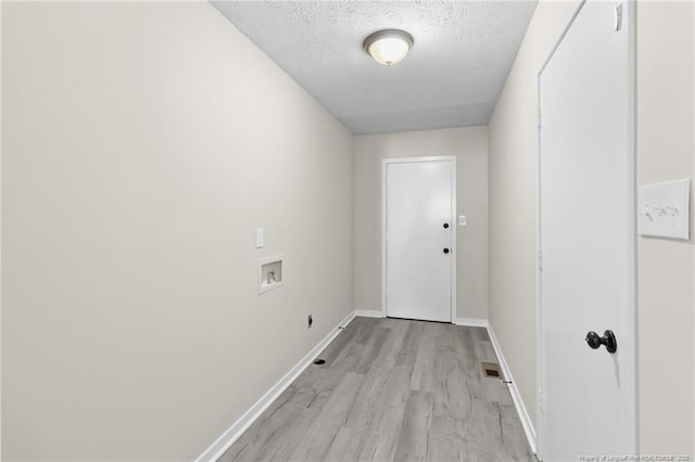 entryway featuring visible vents, a textured ceiling, light wood-type flooring, and baseboards