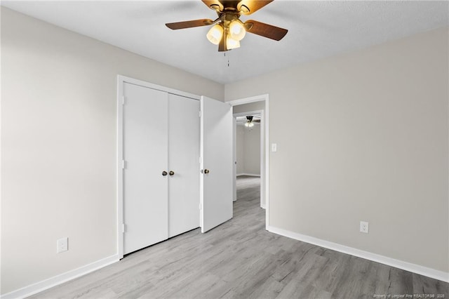 unfurnished bedroom featuring a closet, ceiling fan, baseboards, and wood finished floors