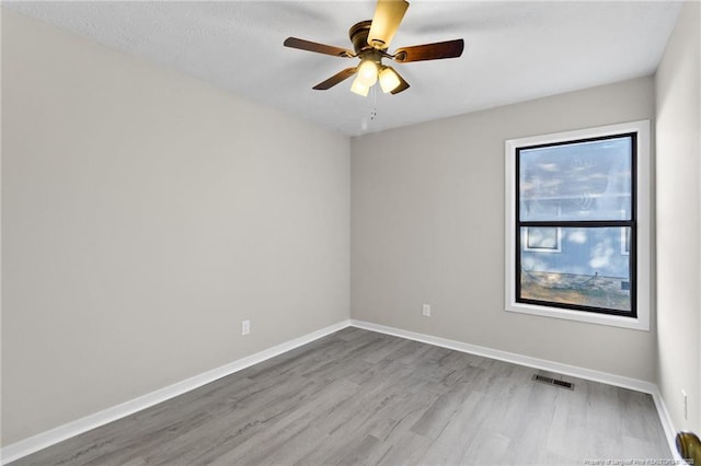 unfurnished room with a ceiling fan, baseboards, and wood finished floors