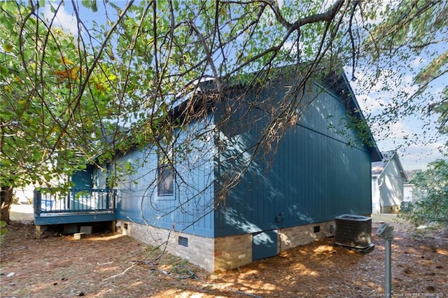 view of side of property with crawl space and cooling unit