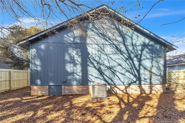 view of side of property featuring cooling unit and fence