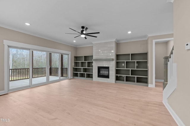 unfurnished living room with light hardwood / wood-style floors, ceiling fan, ornamental molding, and a premium fireplace