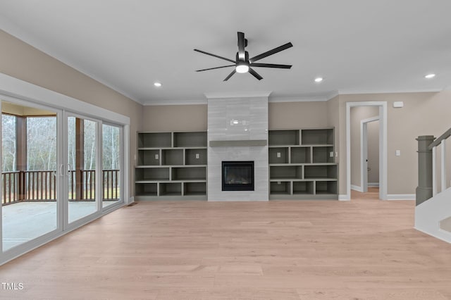 unfurnished living room featuring a fireplace, ceiling fan, light hardwood / wood-style flooring, and ornamental molding