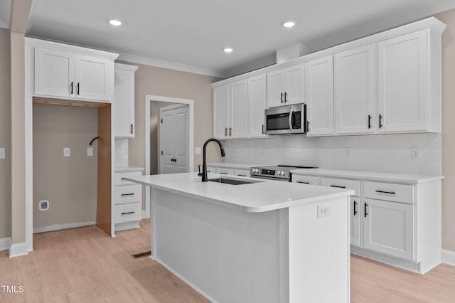 kitchen featuring stainless steel appliances, white cabinetry, a center island with sink, and sink