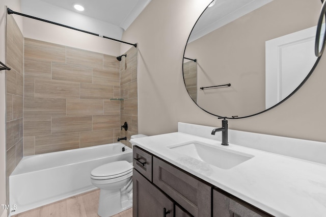 full bathroom with vanity, tiled shower / bath, crown molding, toilet, and wood-type flooring