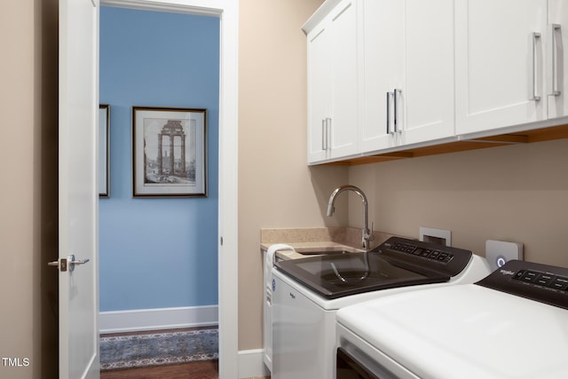 washroom featuring cabinets, washing machine and clothes dryer, and sink