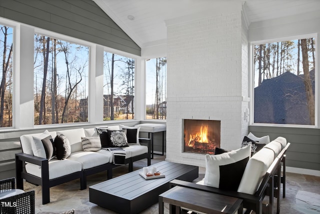 sunroom / solarium featuring lofted ceiling and an outdoor brick fireplace