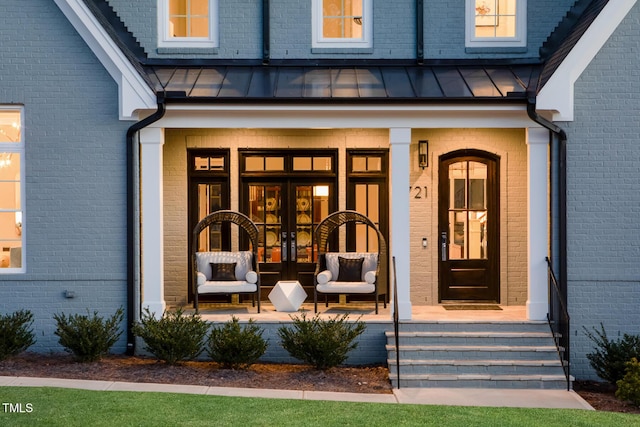 view of exterior entry with french doors and covered porch