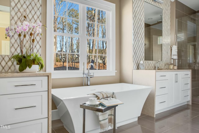 bathroom with tile patterned floors, vanity, and a tub