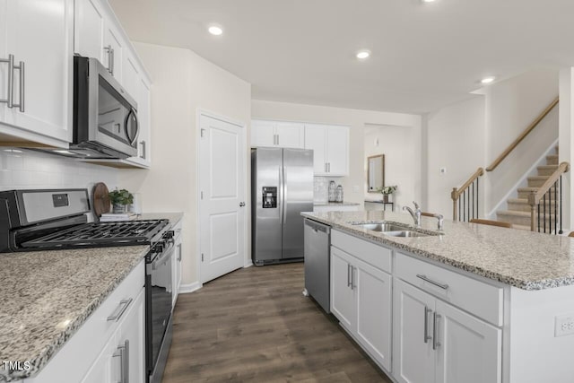 kitchen featuring a kitchen island with sink, sink, white cabinets, and appliances with stainless steel finishes