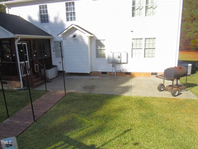 back of property with a yard, a patio, and a sunroom