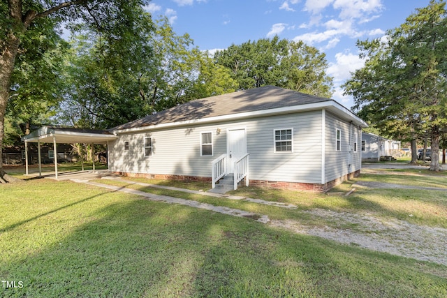 back of house featuring a yard and a carport