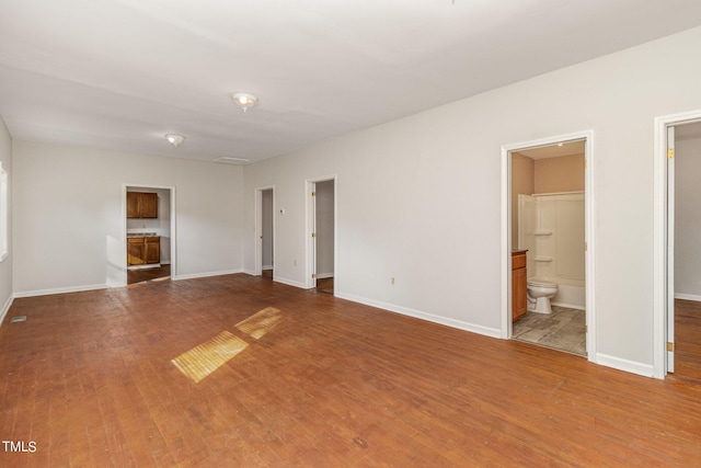 unfurnished bedroom featuring hardwood / wood-style floors and ensuite bathroom