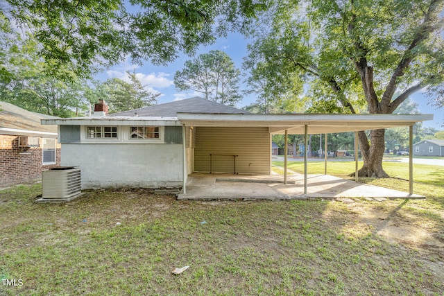 back of house featuring a lawn and central AC