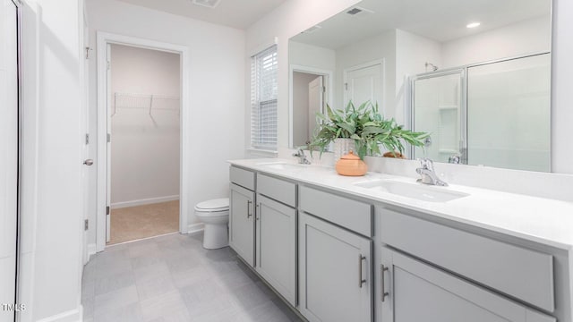 bathroom featuring vanity, toilet, and a shower with shower door