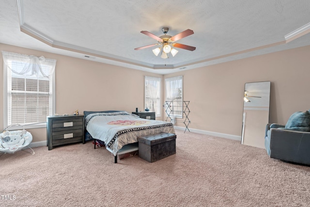 bedroom featuring multiple windows, a raised ceiling, and ceiling fan