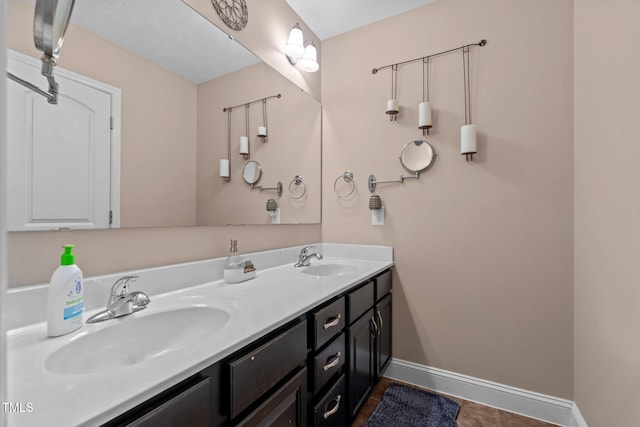 bathroom with tile patterned flooring, vanity, and a textured ceiling