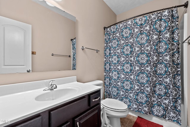 bathroom with a textured ceiling, vanity, and toilet