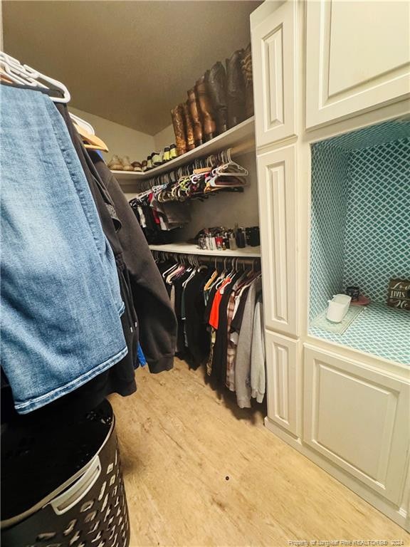 walk in closet featuring light hardwood / wood-style flooring