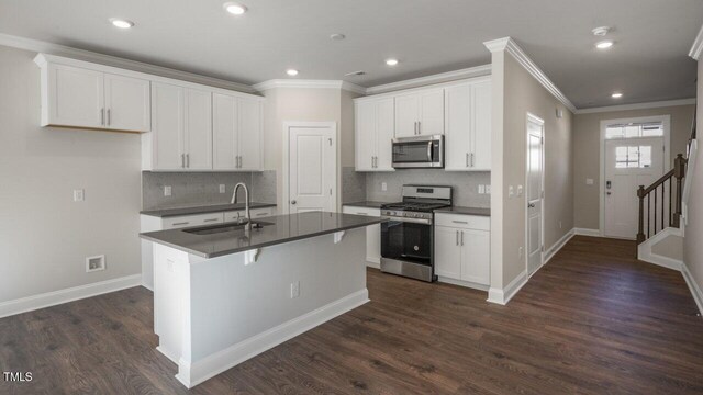 1825 Hinesley Dr, Durham, NC 27703 - kitchen with appliances with stainless steel finishes, a sink, dark countertops, crown molding, and backsplash