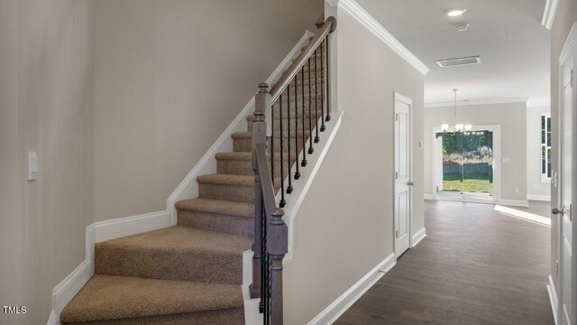 1825 Hinesley Dr, Durham, NC 27703 - stairway featuring wood finished floors, crown molding, a chandelier, and baseboards