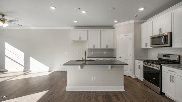 1825 Hinesley Dr, Durham, NC 27703 - kitchen with stainless steel appliances, a sink, ornamental molding, dark countertops, and a ceiling fan