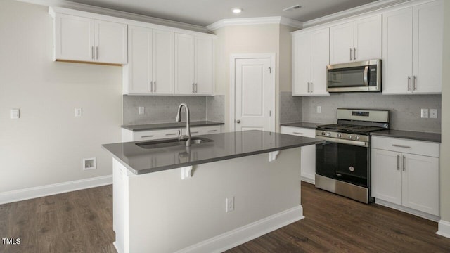 1825 Hinesley Dr, Durham, NC 27703 - kitchen with appliances with stainless steel finishes, a sink, dark countertops, dark wood-style floors, and baseboards