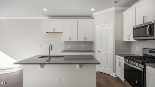 1825 Hinesley Dr, Durham, NC 27703 - kitchen featuring appliances with stainless steel finishes, a sink, dark countertops, crown molding, and dark wood-style floors