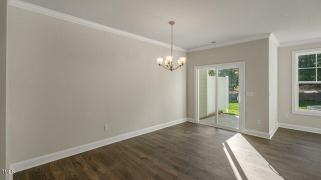 1825 Hinesley Dr, Durham, NC 27703 - unfurnished dining area featuring dark wood-type flooring, healthy amount of natural light, a chandelier, ornamental molding, and baseboards