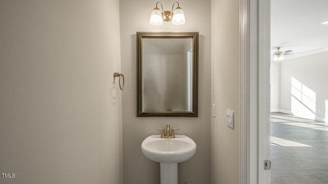 1825 Hinesley Dr, Durham, NC 27703 - bathroom featuring a sink, wood finished floors, and baseboards