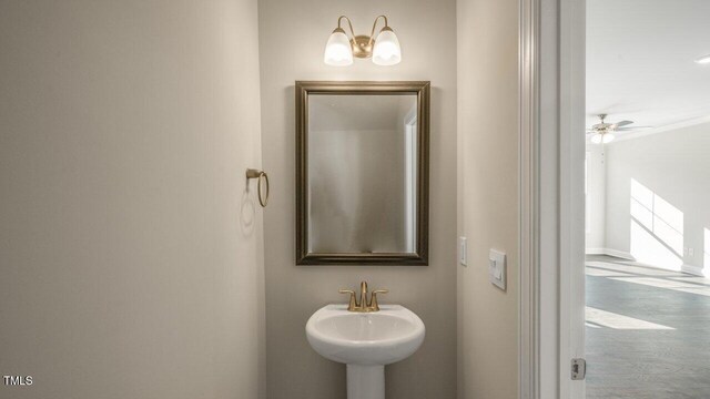 1825 Hinesley Dr, Durham, NC 27703 - bathroom featuring a sink, wood finished floors, and baseboards