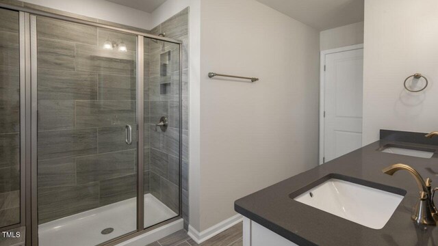 1825 Hinesley Dr, Durham, NC 27703 - bathroom with a shower stall, double vanity, and baseboards