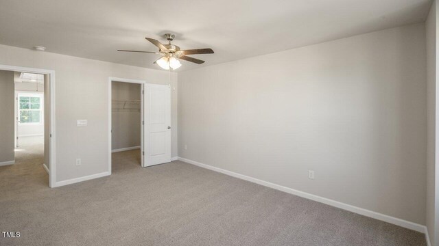 1825 Hinesley Dr, Durham, NC 27703 - unfurnished bedroom with light carpet, baseboards, a walk in closet, a closet, and ceiling fan