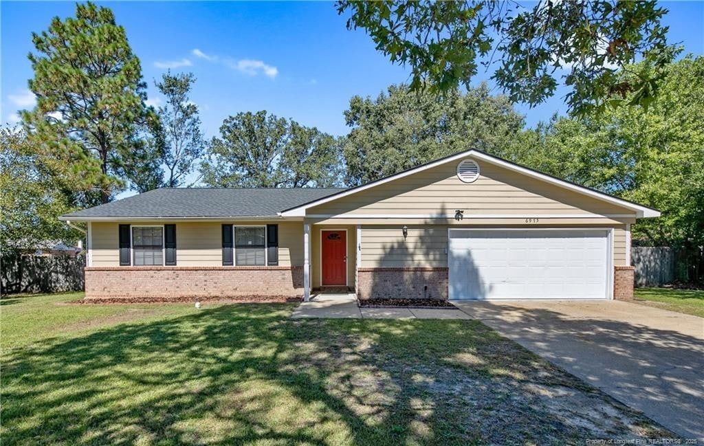 single story home with a garage and a front yard