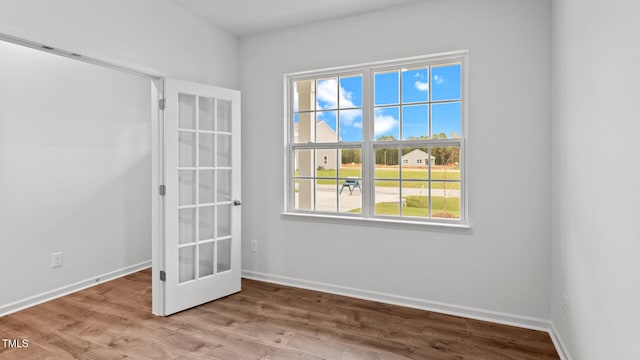 empty room with french doors and light hardwood / wood-style flooring