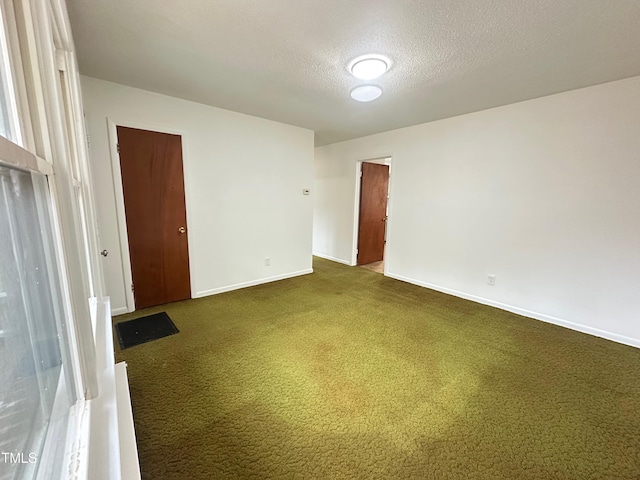 carpeted empty room featuring a textured ceiling