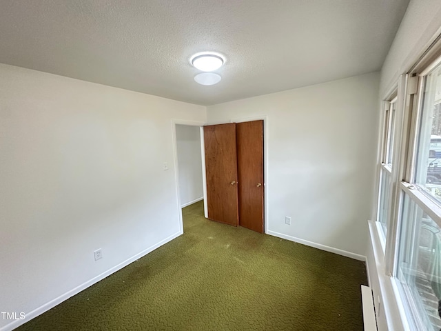 unfurnished room with carpet floors and a textured ceiling