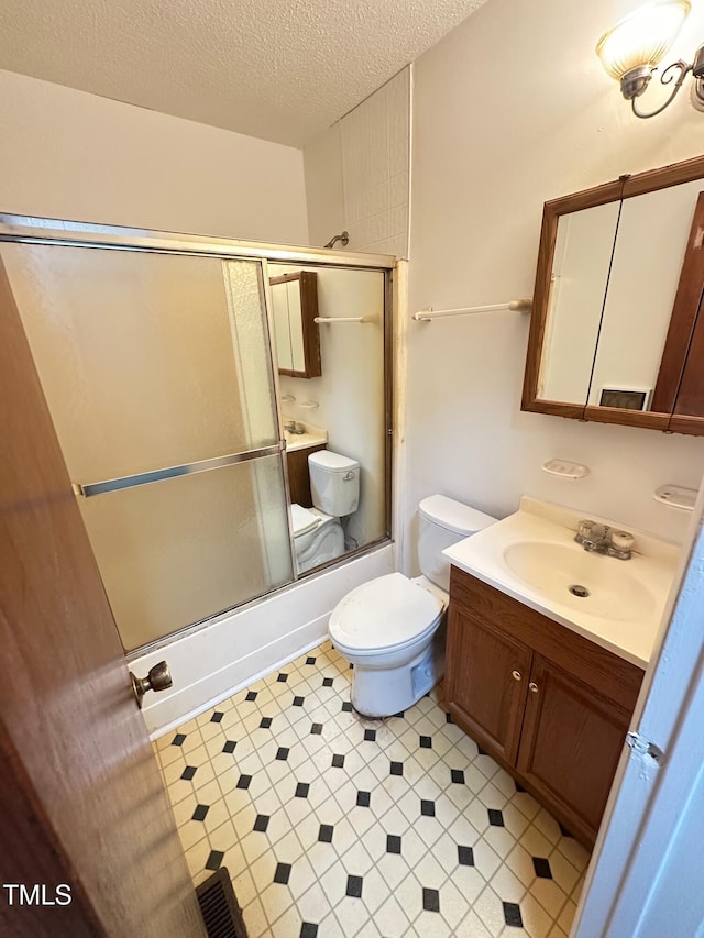 full bathroom with enclosed tub / shower combo, vanity, a textured ceiling, and toilet