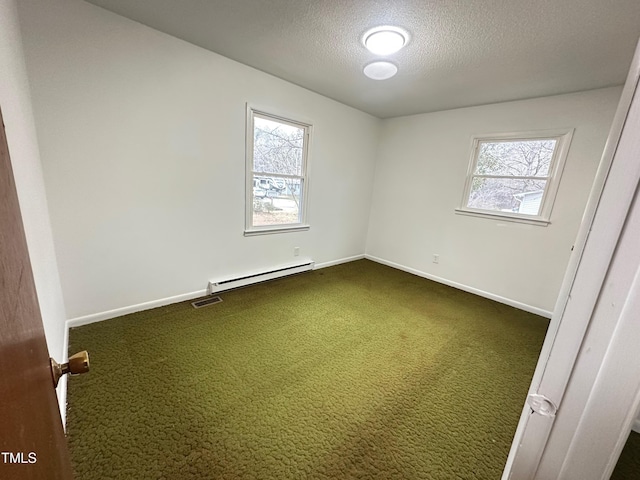 unfurnished room with baseboard heating, carpet flooring, a textured ceiling, and a wealth of natural light