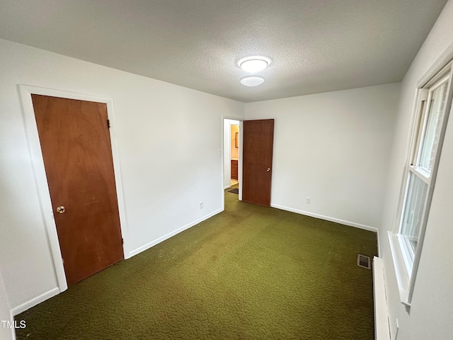 carpeted spare room with a textured ceiling