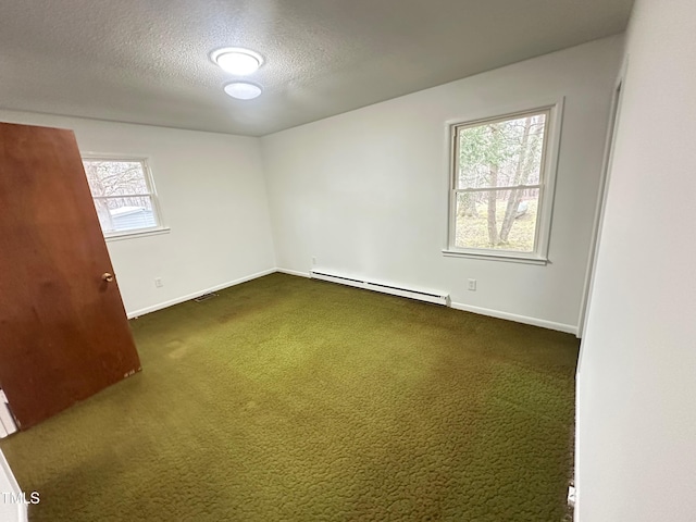 carpeted spare room featuring a baseboard heating unit and a textured ceiling