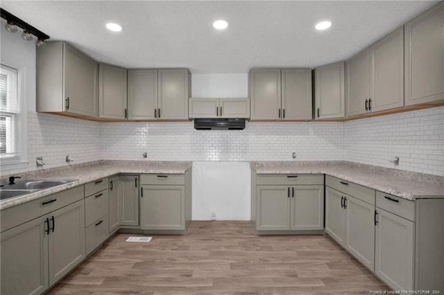 kitchen featuring light wood-type flooring, tasteful backsplash, and gray cabinetry