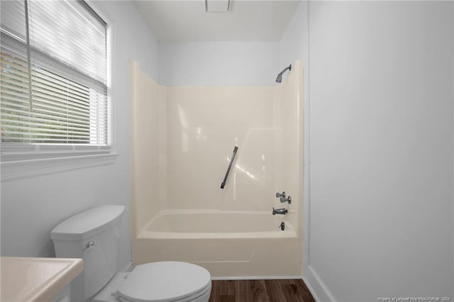 bathroom featuring toilet, wood-type flooring, and tub / shower combination