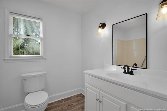 bathroom with hardwood / wood-style floors, vanity, and toilet