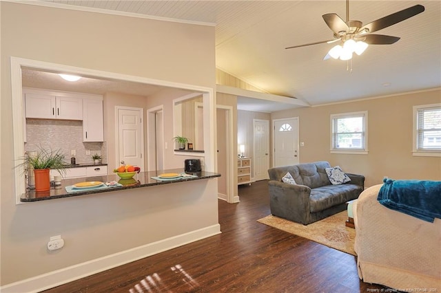 living room with vaulted ceiling, ceiling fan, ornamental molding, and dark hardwood / wood-style floors