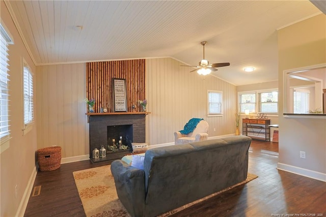 living room featuring lofted ceiling, dark wood-type flooring, a wealth of natural light, and crown molding