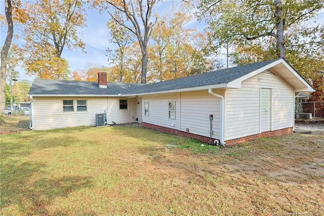 back of property featuring a lawn and cooling unit