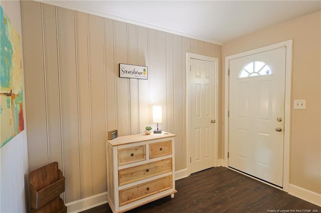 foyer entrance with dark wood-type flooring and ornamental molding