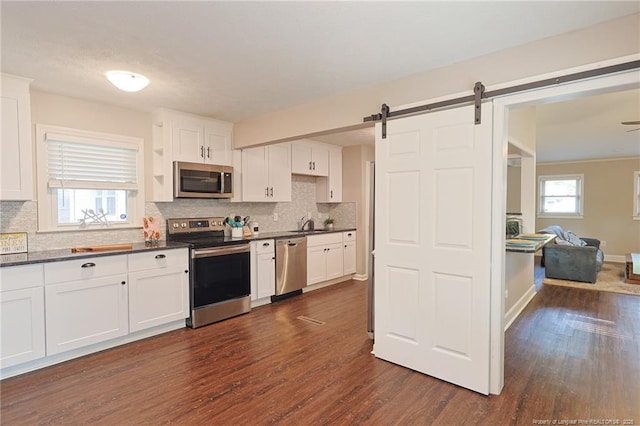 kitchen featuring white cabinets, appliances with stainless steel finishes, and dark hardwood / wood-style floors