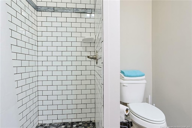 bathroom featuring toilet and tiled shower